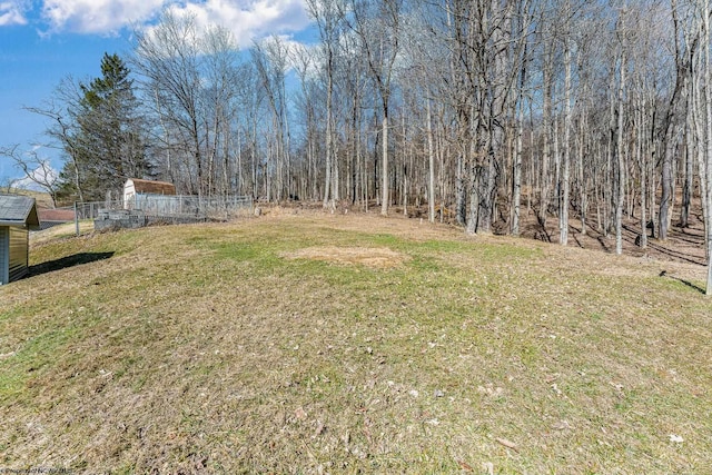 view of yard with a forest view and fence