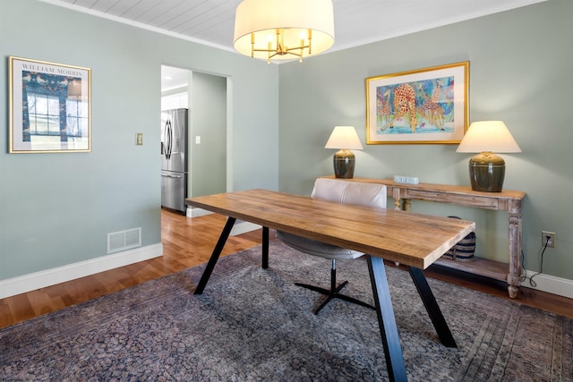 home office featuring baseboards, visible vents, wood finished floors, and ornamental molding