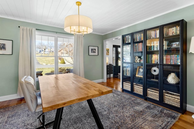 dining space featuring ornamental molding, wood ceiling, baseboards, and wood finished floors