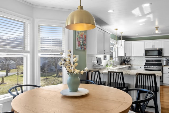 dining space featuring recessed lighting, crown molding, and wood finished floors