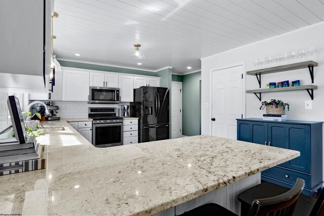 kitchen with a peninsula, a sink, appliances with stainless steel finishes, backsplash, and light stone countertops