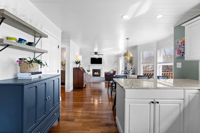 kitchen featuring a warm lit fireplace, dark wood-type flooring, white cabinets, open floor plan, and open shelves