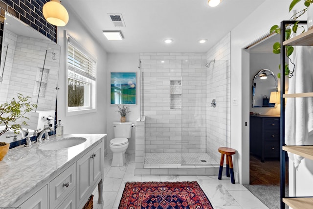 bathroom featuring marble finish floor, a shower stall, visible vents, and vanity