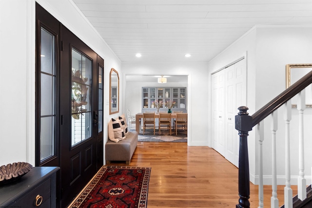 foyer featuring ornamental molding, recessed lighting, stairway, and light wood finished floors