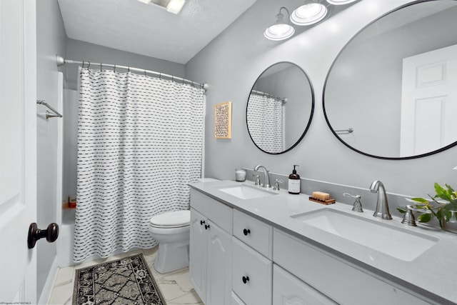 full bathroom with marble finish floor, a sink, toilet, and double vanity