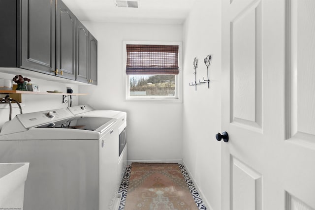 washroom featuring washing machine and dryer, cabinet space, visible vents, and baseboards