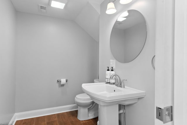 bathroom featuring lofted ceiling, toilet, wood finished floors, visible vents, and baseboards