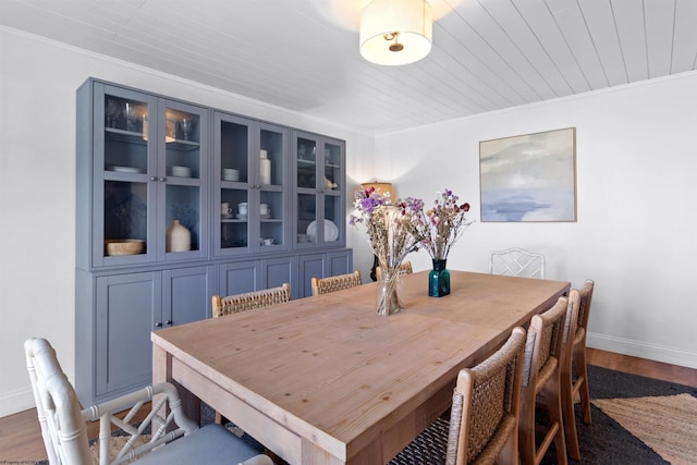 dining area featuring wood ceiling, baseboards, wood finished floors, and ornamental molding