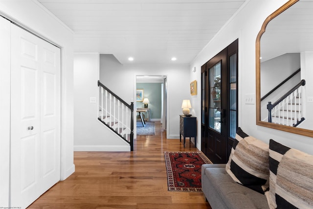 entryway with crown molding, recessed lighting, wood finished floors, baseboards, and stairs