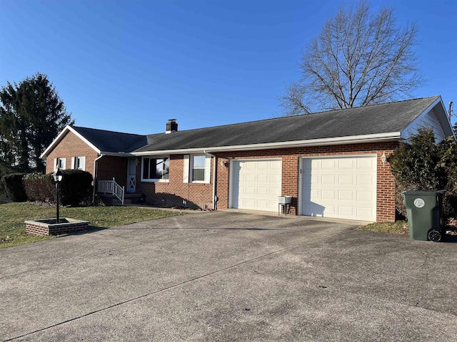 ranch-style home featuring a garage, a chimney, concrete driveway, and brick siding