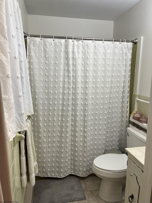 full bathroom featuring toilet, a shower with curtain, and tile patterned floors