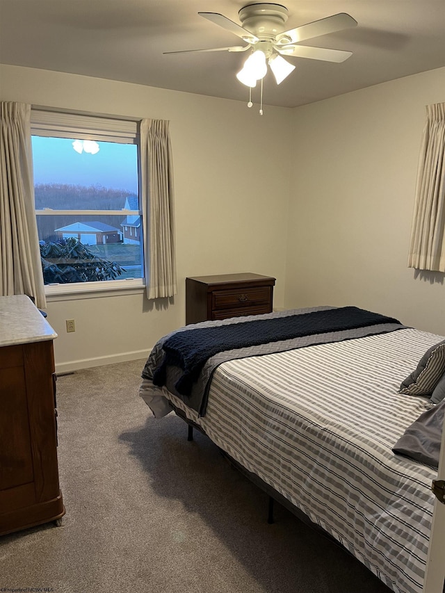 carpeted bedroom with a ceiling fan and baseboards