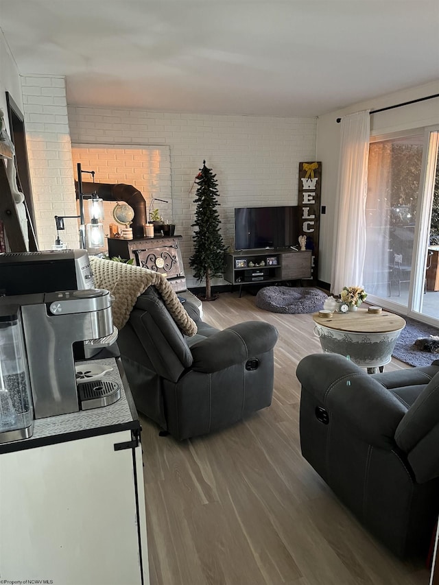 living room with brick wall and wood finished floors