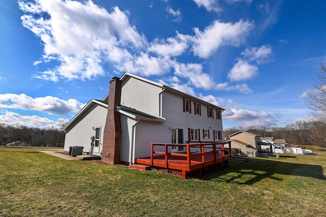 back of house featuring a yard, a chimney, central AC unit, and a wooden deck