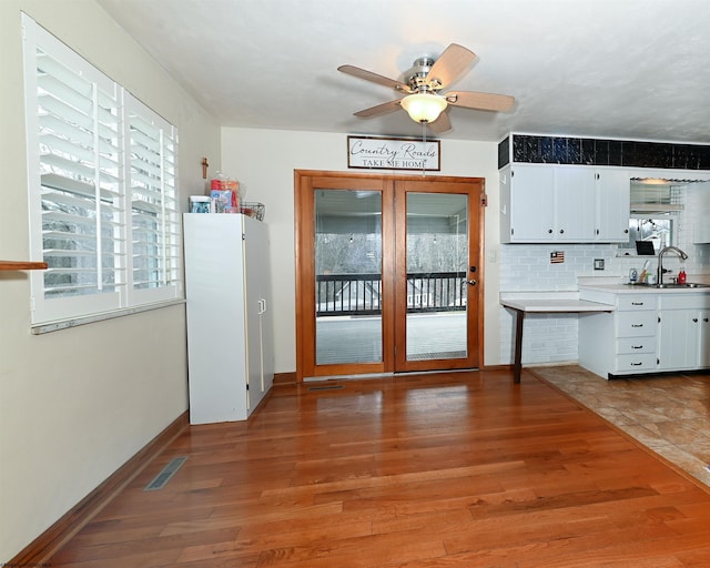 kitchen featuring light wood-type flooring, visible vents, light countertops, and white cabinets