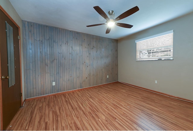 unfurnished room with ceiling fan, baseboards, and wood finished floors