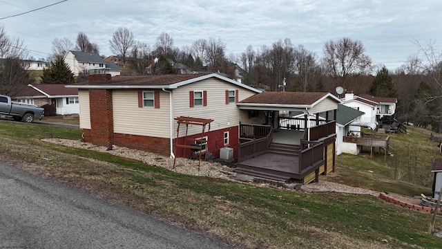 view of front of property with central air condition unit, a front lawn, and a deck