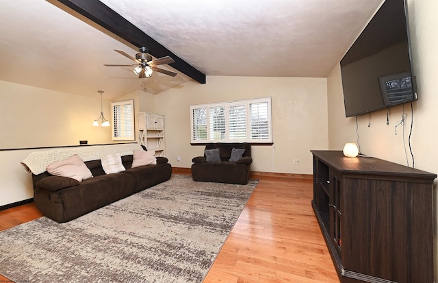 living room with baseboards, ceiling fan, lofted ceiling with beams, and light wood finished floors