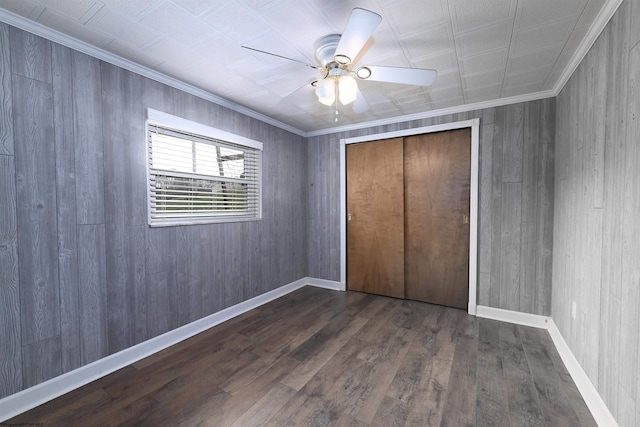 unfurnished bedroom with wood finished floors, a ceiling fan, baseboards, ornamental molding, and a closet