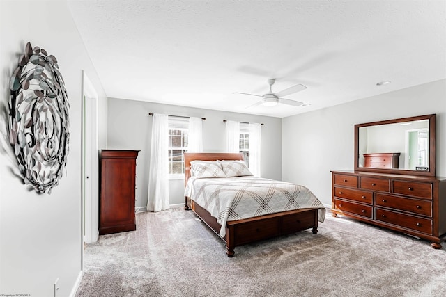 bedroom with a ceiling fan, light colored carpet, and baseboards