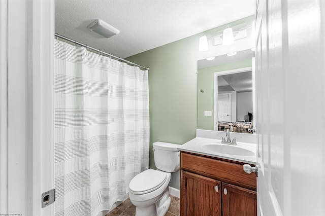 full bathroom featuring toilet, curtained shower, a textured ceiling, and vanity