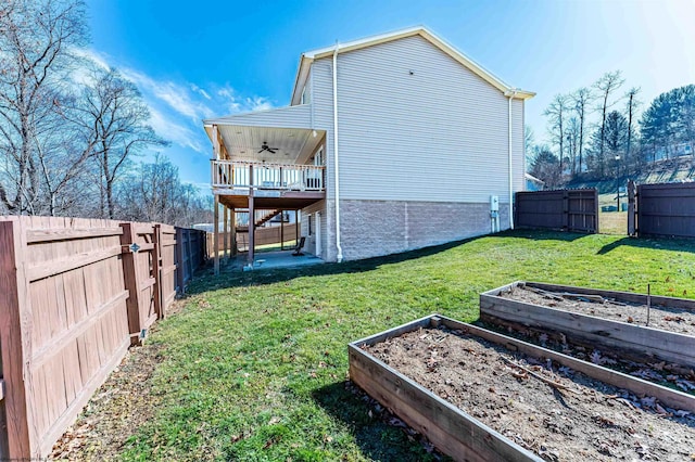 exterior space featuring a yard, a fenced backyard, a garden, and a ceiling fan