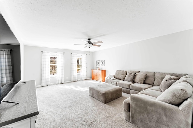 living room with carpet floors, ceiling fan, a textured ceiling, and baseboards