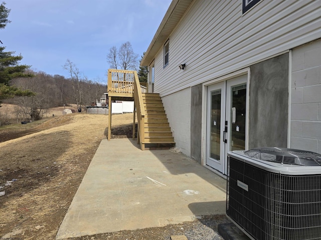 view of patio featuring a deck, central AC, and stairway