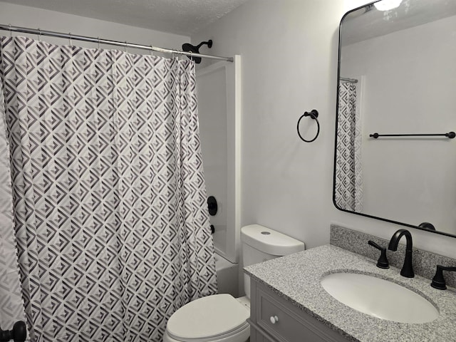 bathroom with a textured ceiling, shower / bath combination with curtain, vanity, and toilet