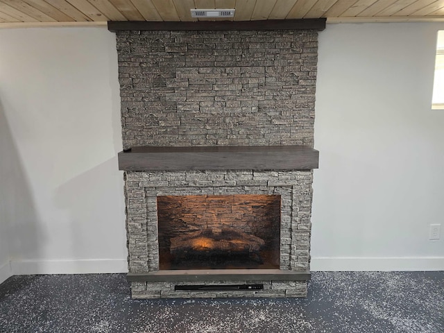 details with visible vents, a fireplace, wood ceiling, and baseboards