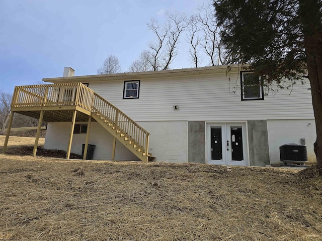 rear view of house with central air condition unit, a chimney, a wooden deck, and stairs