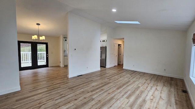 unfurnished room featuring a skylight, visible vents, light wood-style flooring, and baseboards