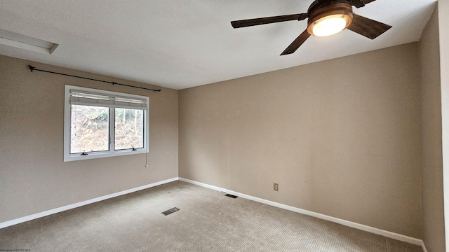 spare room featuring ceiling fan, carpet floors, visible vents, and baseboards