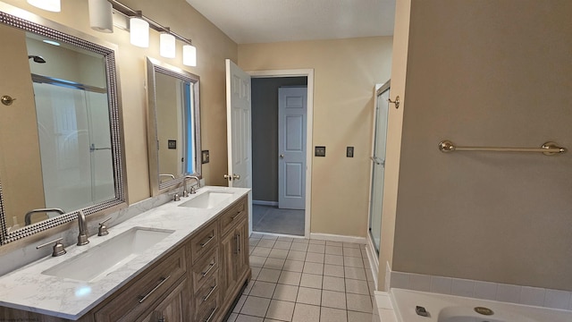 bathroom with double vanity, a stall shower, tile patterned flooring, and a sink