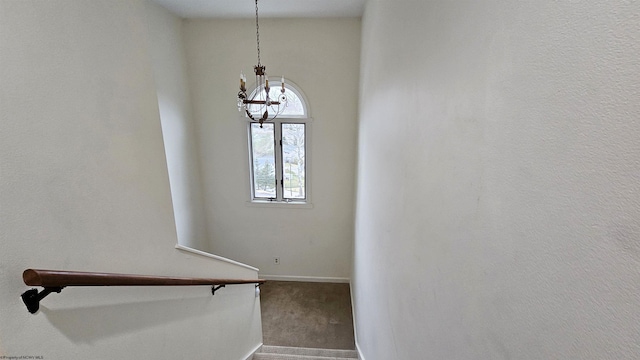 staircase with carpet floors, baseboards, and a chandelier