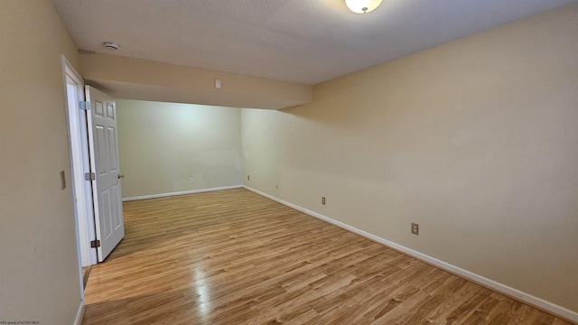 empty room featuring light wood-style flooring and baseboards