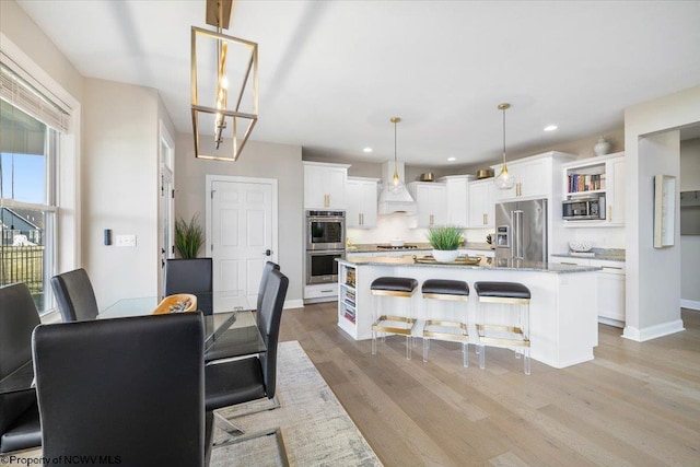 dining room featuring recessed lighting, baseboards, and light wood finished floors