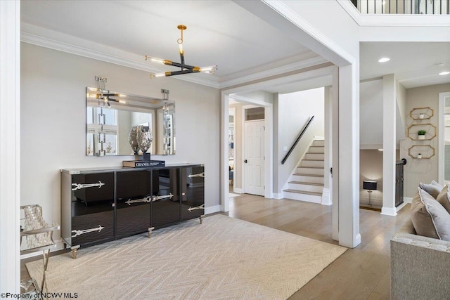 interior space featuring stairs, crown molding, baseboards, and wood finished floors