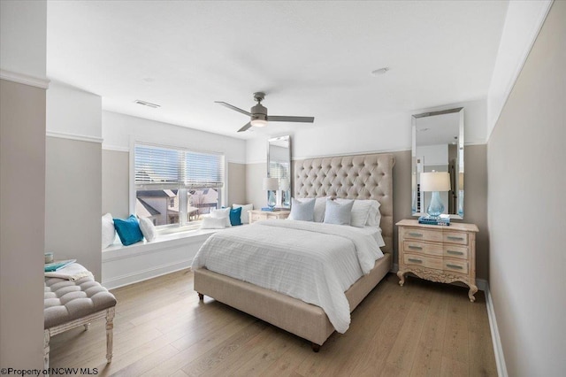 bedroom with hardwood / wood-style flooring, ceiling fan, visible vents, and baseboards