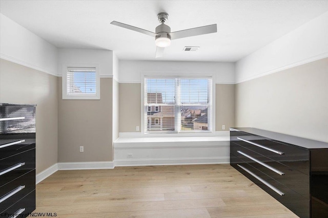 interior space with light wood-type flooring, visible vents, baseboards, and multiple windows