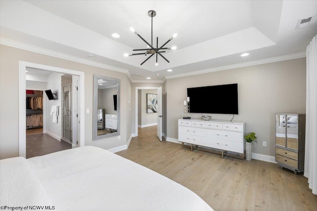 bedroom with a tray ceiling, recessed lighting, baseboards, and wood finished floors