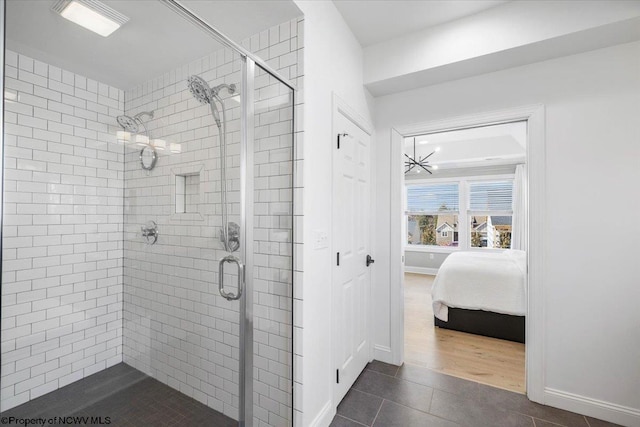 ensuite bathroom featuring baseboards, a stall shower, ensuite bath, and tile patterned floors