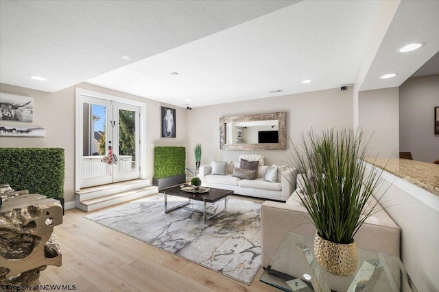 living area featuring recessed lighting, wood finished floors, and french doors