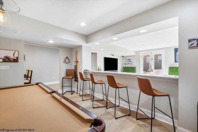 interior space with baseboards, french doors, light wood-style flooring, and recessed lighting