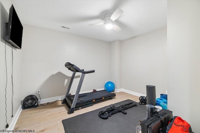 workout area featuring ceiling fan, wood finished floors, visible vents, and baseboards