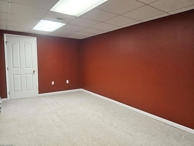 finished basement with carpet floors, a drop ceiling, and baseboards