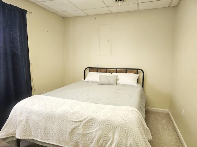 bedroom with a paneled ceiling, carpet flooring, electric panel, and baseboards