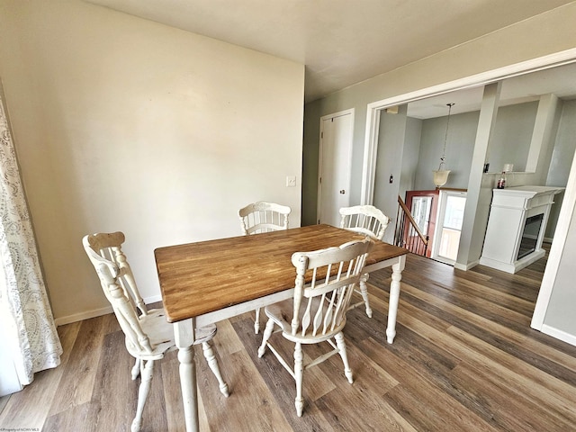 dining area with baseboards and wood finished floors