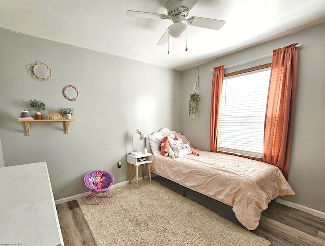 bedroom with wood finished floors, a ceiling fan, and baseboards