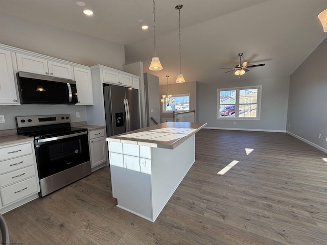 kitchen featuring lofted ceiling, stainless steel appliances, dark wood-style flooring, and a center island